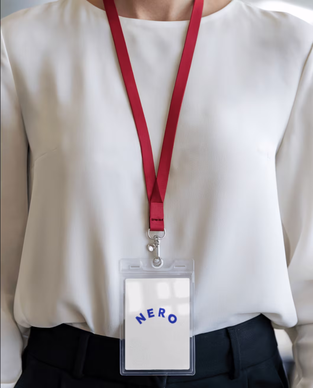Person wearing a NERO badge on a red lanyard